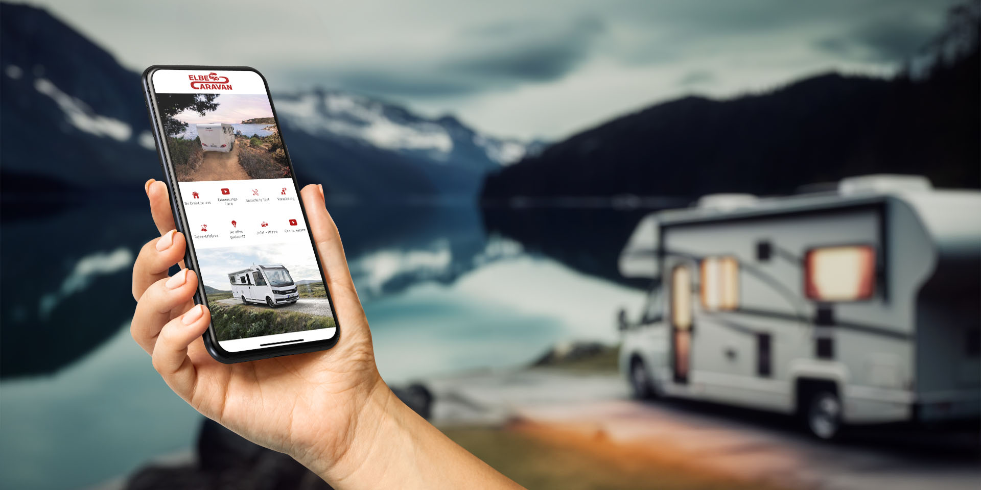 Eine Person steht mit Smartphone vor einem Wohnmobil und nutzt die Kunden-App von Elbe Caravan.